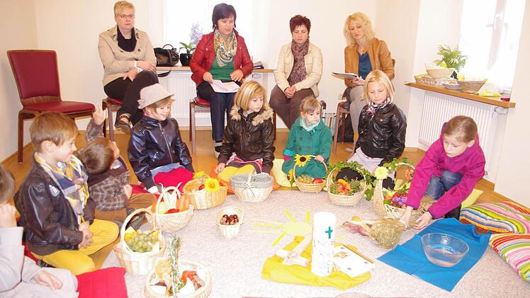 Marina (rechts) legt einen Getreidebund neben die Kerze. Mit im Bild sind (von links): Louis, Benjamin, Jana, Leonie, Marie und Lisa sowie das Team der Kinderkirche (ab 2. v.l.): Juliane Eidloth, Sandra Kittel und Katja Hoderlein.  Foto: Heike Schülein