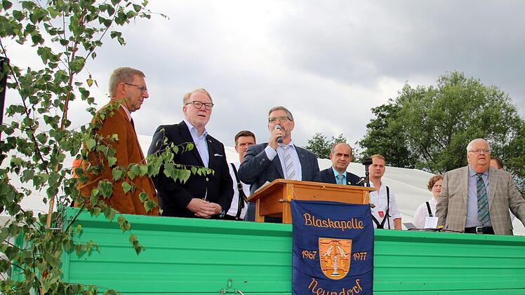 Ein bunter Reigen aus Kapellen und drei Gesangvereinen versammelte sich am Sonntagnachmittag auf dem Neundorfer Festplatz zum Kreismusikfest und Feier des 50-jährigen Jubiläums der Blaskapelle Neundorf. Vom Anhänger aus begrüßte Schirmherr und Landrat Michael Busch die Teilnehmer. Von links: Bürgermeister Wolfgang Bauersachs, MdB Hans Michelbach, Vorsitzender Andreas Böhm, Busch, Thomas Kolb (NBMB), die Dirigenten Sascha Dalke und Carmen Helmprobst sowie Werner Pörner und Ronald Friedrich (eb...