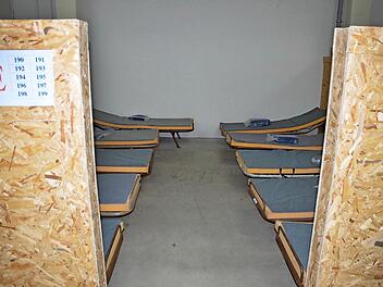 Leere Betten stehen in der Notunterkunft in Rödental. Sollte die Zahl der Flüchtlinge wieder steigen, könnten hier bis zu 300 Personen vorübergehend einquartiert und versorgt werden. Zurzeit wird das frühere Fabrikgebäude nicht genutzt, nur bewacht. Foto: Rainer Lutz