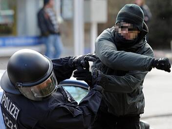 Ein Demonstrant schlägt in Lübeck auf einen Polizisten ein. Auch in Bayern nimmt die Gewalt gegen Polizisten stetig zu.  Foto: Carsten Rehder, dpa