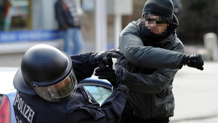 Ein Demonstrant schlägt in Lübeck auf einen Polizisten ein. Auch in Bayern nimmt die Gewalt gegen Polizisten stetig zu.  Foto: Carsten Rehder, dpa