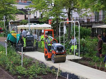Die Wege im Rosengarten sind mit schwarzem Asphalt aufgebaut und haben eine sndfarbene Deckschicht, die in dieser Woche eingebracht wurde. Gestern begann der Abbau der Zufahrtsrampe, für Sonntag, 26. Juni, ist die Einweihung geplant. Foto: Ralf Ruppert