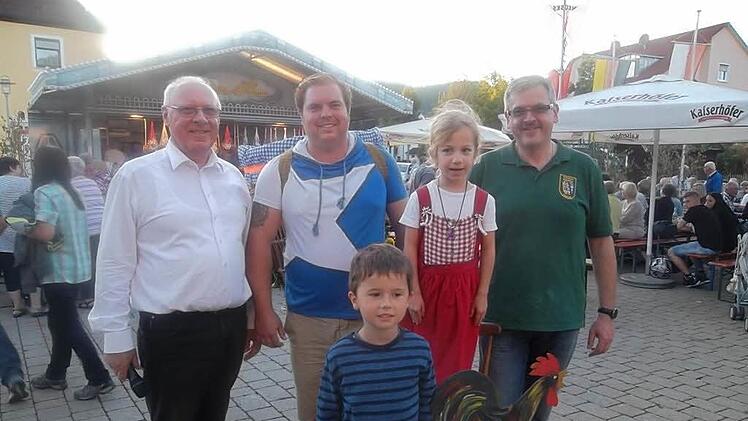 Der Hahnenschlag als traditioneller Abschluss der Neusiche Kerwa (von links): Günther Hanna, Zweiter Vorsitzender des Vereins für Kulturpflege und Moderator der Veranstaltung, Hahnenkönig 2016 Axel Schrepfer, "Glücksfee" Luzy Schedel, die die Losnummern zog, und Markus Hummel, Vorsitzender des Musikvereins Flößerkapelle. Vorne im Bild ist Kinder-Hahnenkönig Jonas.  Foto: Jutta Dietzel