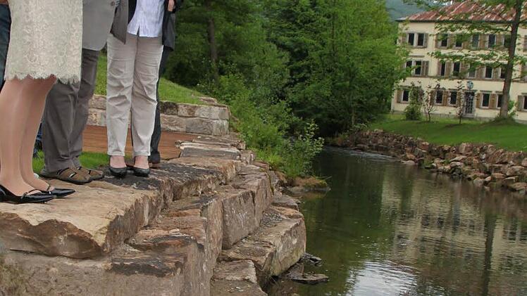 Armin Sauermann vom Fischereiverein zeigt Kurdirektorin Andrea Schallenkammer (links) und Bürgermeisterin Brigitte Meyerdierks den Äschen-Nachwuchs.