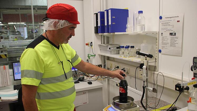 Norbert Röder zeigt das alte Verfahren der Füllmengenkontrolle: Wiegen, Tara (Verpackung) abziehen, Dichte des Getränkes berücksichtigen, händisch eintragen. Heute berechnet das der Computer.