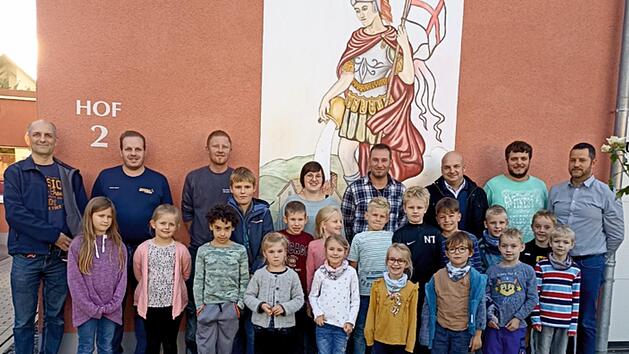 Die M&auml;dchen und Jungen der Kinderfeuerwehr  sowie (hinten von links) die Kommandanten Christian N&ouml;th und Manuel Gessner, Vorstand Dominik Bieber, Lena Tr&auml;gner, Fabian N&ouml;th, B&uuml;rgermeister Michael Kastl, Domenic Brenz, Frank Chwojka pr&auml;sentieren sic...