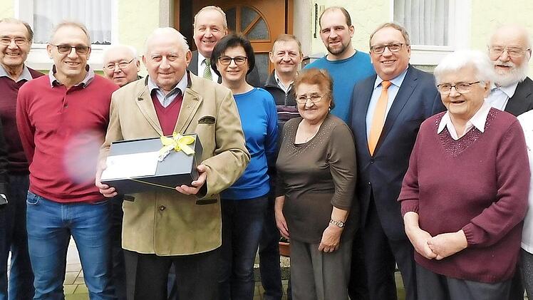 Georg Münch (mit Geschenk) im Kreis von Verwandten und Freunden mit 2. Bürgermeister Klaus Amschler (rechts hinter dem Jubilar) und stellvertretendem Landrat Dieter Schaar (Fünfter von rechts). Foto: Horst Wunner
