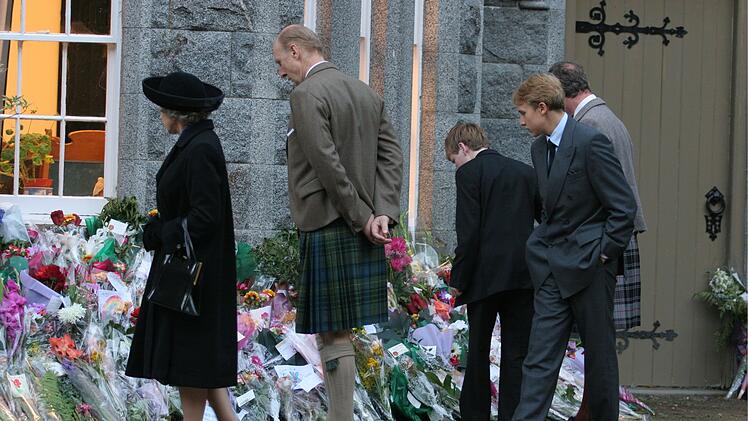 Die Queen (Helen Mirren, l.) sieht sich die Blumen an, die die Menschen an den Buckingham Palace gebracht haben, um an die tote Diana zu erinnern.
