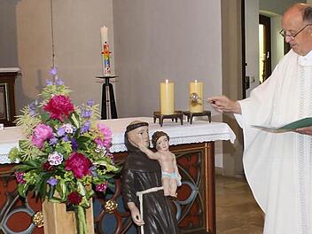 Pater Manfred Jasper segnet die Antoniusfigur, die einst in der Michaelskapelle gestanden haben soll.  Foto: Nöth