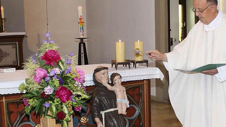 Pater Manfred Jasper segnet die Antoniusfigur, die einst in der Michaelskapelle gestanden haben soll.  Foto: Nöth