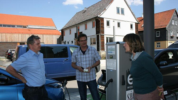 "Betankung" eines Elektroautos an der Hauptstraße in Mitwitz. Die E-Mobilität ist ein weiteres Projekt des Vereins. Rechts Elisabeth Hoffmann, die selbst ein E-Auto besitzt, sowie  Wolfgang Degelmann und Projektverantwortlicher Martin KastnerMaria Löffler