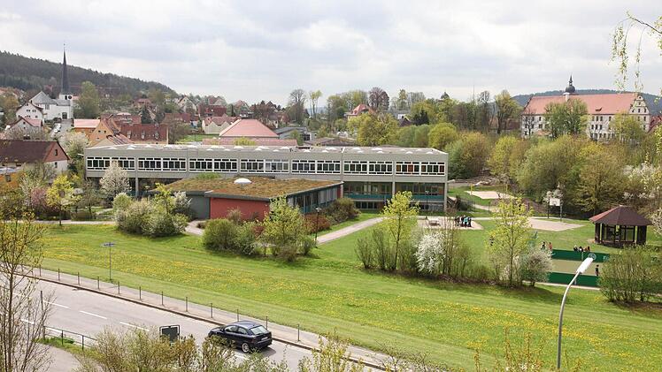 Auf der kreiseigenen Grünfläche zwischen Coburger Straße (Vordergrund) und der Realschule (Hintergrund) soll das neue Hallenbad gebaut werden. Archivbild: Michael Will