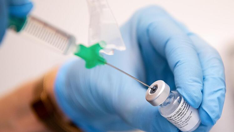 Eine Klinik-Mitarbeiterin zieht den Covid-19 Impfstoff von Biontech/Pfizer für eine Impfung auf eine Spritze.