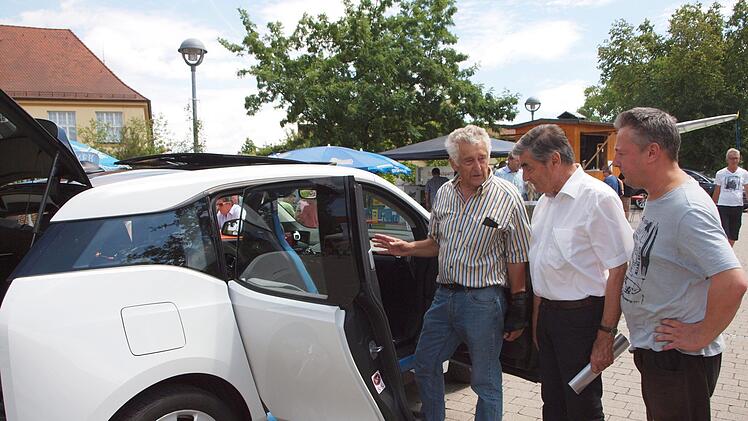 Klaus Gagel (links) aus Michelau stellte interessierten Besuchern sein Elektroauto BMW i3 ausführlich vor.
