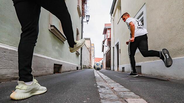 Gelernt ist gelernt: Philipp Pfeiffer (li.) und Robin Renner spielten in der Weltkulturerbe-Stadt Bamberg die Sportfloskel des 15. Dezember nach. Die Fu&szlig;baller kicken f&uuml;r den FC Eintracht Bamberg, der in der Landesliga Nordost auf Rang 1 &uuml;berwintert. Foto: Matthias Hoch