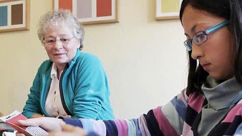 Inci sucht sich die passende Farbe aus. Im Hintergrund beobachtet Pä-dagogin Sigrid Groh das Geschehen.