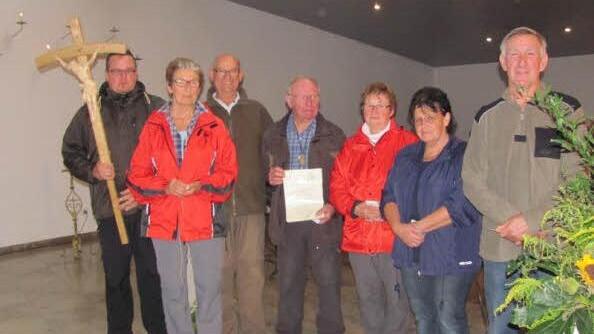Eine Dankesurkunde erhielt bei der Wallfahrt Initiator Erhard Reuss (Bildmitte) Kreuzträger Andreas Seidenthal (von links) freute sich auch über die Jubiläumspilger Christa und Bernd Hornung, Christa Büchner, Gerda Schubert und Harald Rest, die zum 25. Mal teilnahmen. Initiator Siegfried Schuhmann fehlte wegen Krankheit. Foto: Christa Schmähling