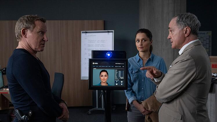 Für  Kriminalrat Schaaf (Rainer Laupichler, rechts) ist wichtig, dass korrekt mit dem KI-Kommissar umgegangen wird. Keine sensiblen Daten der Polizei dürfen nach außen gelangen. Overbeck (Roland Jankowsky) und Isabel Wolfangel (Sarah Alles-Shahkarami) wissen das Gerät für sich zu nutzen. Allerdings macht das manchmal, was es will.