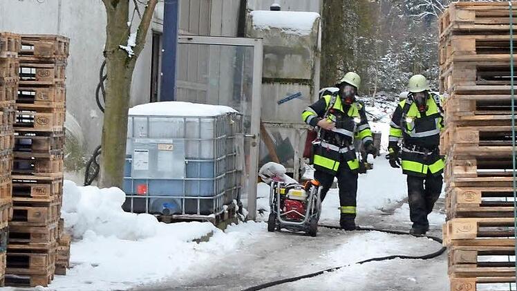 Zwei Feuerwehrmänner kommen aus der Halle, in der sie die Explosion einer brennenden Gasflasche verhindern konnten. Fotos: Rainer lutz