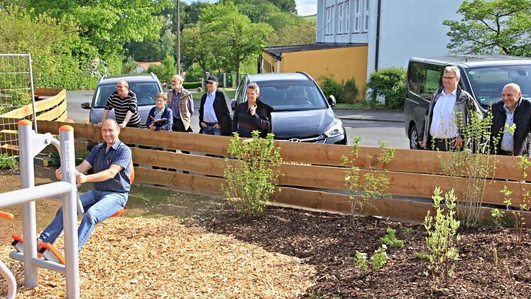 Das "Seniorenspielgerät" am Spielplatz in Untermerzbach testete Gemeinderat Gerald Karl. Dazu hatte der sportliche Hauptfeldwebel der Reserve den Bretterzaun überwunden, hinter dem der Bauausschuss mit Bürgermeister Helmut Dietz (Zweiter von rechts) die Leibesertüchtigung des Gremiumsmitglieds beobachte. Foto: Helmut Will