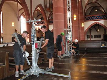 Mitarbeiter der Firma WSV Messebau haben am Freitagmorgen Traverse in der Kirche aufgebaut. An die zwei Tore und zwei Ständer hängen die ZDF-Techniker ihre Scheinwerfer für den Gottesdienst. Foto: Kerstin Väth