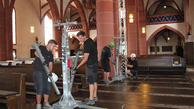 Mitarbeiter der Firma WSV Messebau haben am Freitagmorgen Traverse in der Kirche aufgebaut. An die zwei Tore und zwei Ständer hängen die ZDF-Techniker ihre Scheinwerfer für den Gottesdienst. Foto: Kerstin Väth