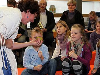 "Vor des Königs Palast steht ein großer Birnbaum", flüstert Märchenerzählerin Helene Sauter und hält den Kindern eine reife Frucht vor die Nase.  Fotos: Pfannes
