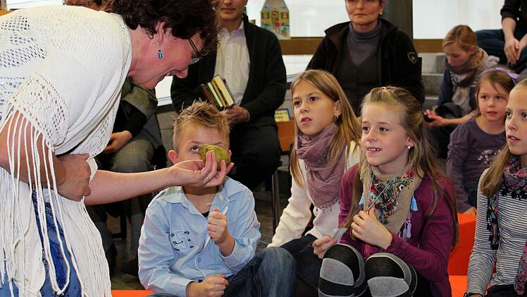 "Vor des Königs Palast steht ein großer Birnbaum", flüstert Märchenerzählerin Helene Sauter und hält den Kindern eine reife Frucht vor die Nase.  Fotos: Pfannes