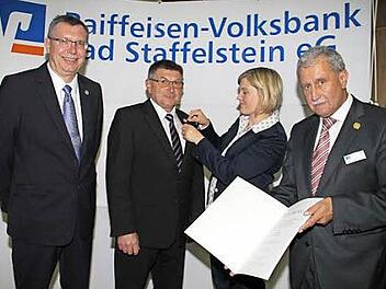 Verbandsprüferin Christina Hartwich steckt Aufsichtsratsvorsitzendem Bruno Krick die silberne Ehrennadel ans Revers. Zur Auszeichnung gratulieren Vorstandsvorsitzender Randolf Menna (rechts) und sein Vorstandskollege Michael Lieb (links).  Foto: Gerda Völk