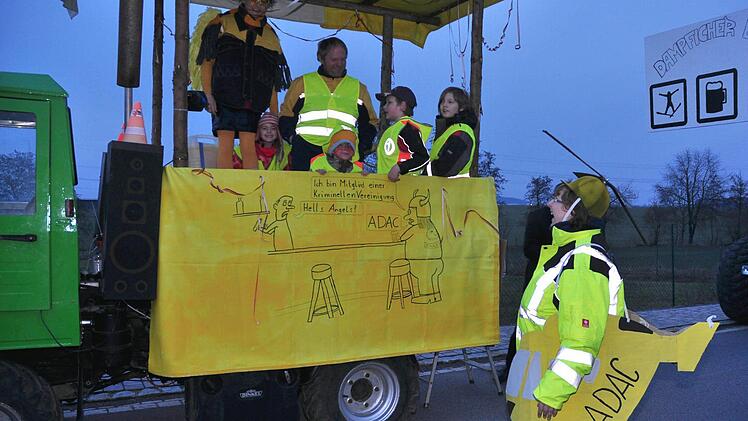 Auch der ADAC wurde zur Zielscheibe des Spotts beim Dampfacher Faschingszug. So sah man einen "gelben Wagen" mit der Aufschrift "ADMC: Allgemeiner Dampfacher Multicar Club", den ein "gelber Engel" in einem Hubschrauber "umkreiste".