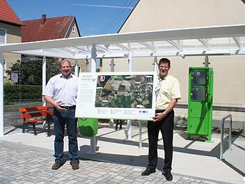 Bürgermeister Klaus Faatz (l.) und Christian Heinrich von der Sparkasse stellen eine der neuen Infotafeln vor. Der Infopavillon mit Schließfächern und Ruhebänken ist der Punkt eins auf dem Rundweg der erneuerbaren Energien. Foto: Evi Seeger