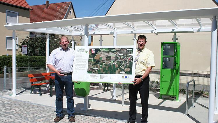 Bürgermeister Klaus Faatz (l.) und Christian Heinrich von der Sparkasse stellen eine der neuen Infotafeln vor. Der Infopavillon mit Schließfächern und Ruhebänken ist der Punkt eins auf dem Rundweg der erneuerbaren Energien. Foto: Evi Seeger