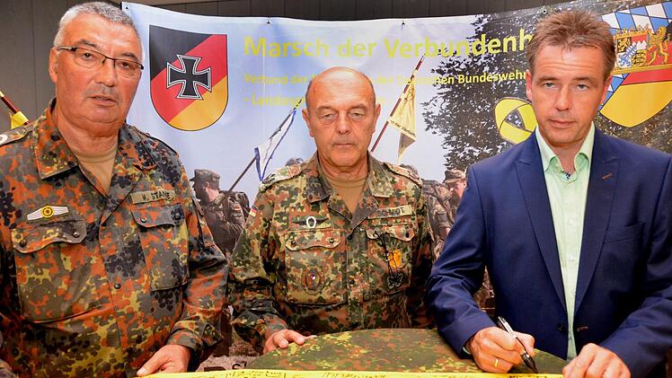 Für die Marktgemeinde Bad Bocklet unterschrieb Kurdirektor Thomas Beck das gelbe Band, das einer Einheit mit auf den Weg in einen Auslandseinsatz gegeben wird (von links: Hauptfeldwebel d.R. Manfred Stange, Oberstleutnant d.R. Johann Schmidt, die beide im Landesvorstand der Bundeswehrreservisten tätig sind, und Kurdirektor Thomas Beck).