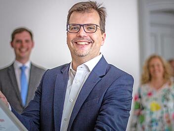 Christian Lange nimmt seinen Hut als Zweiter Bürgermeister. Im Hintergrund unscharf zu erkennen: sein Nachfolger Jonas Glüsenkamp und seine Frau Melanie.  Foto: Lea Schreiber