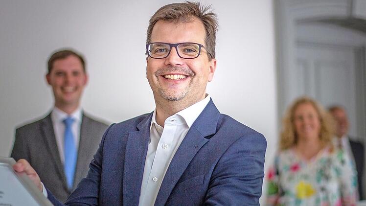 Christian Lange nimmt seinen Hut als Zweiter Bürgermeister. Im Hintergrund unscharf zu erkennen: sein Nachfolger Jonas Glüsenkamp und seine Frau Melanie.  Foto: Lea Schreiber