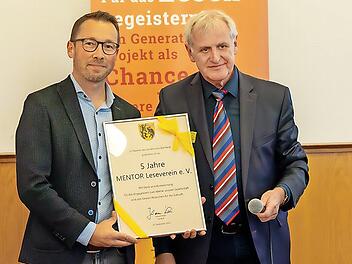 Stellvertretender Landrat Bruno Kellner (r.) überreicht Christian Lorenz, Leiter des Bildungsbüros und Vorstandsmitglied des Mentor-Vereins, die Urkunde zum fünfjährigen Jubiläum.