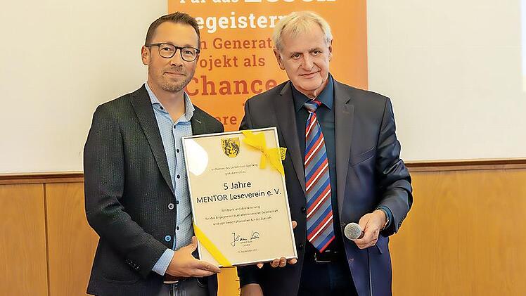 Stellvertretender Landrat Bruno Kellner (r.) überreicht Christian Lorenz, Leiter des Bildungsbüros und Vorstandsmitglied des Mentor-Vereins, die Urkunde zum fünfjährigen Jubiläum.