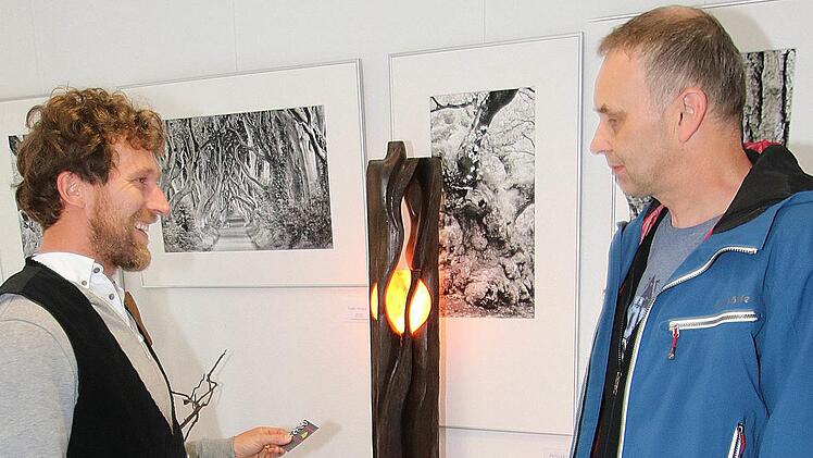 Kunstwerke aus alten Eichenholz-Balken, die viel bewundert wurden, schafft Bildhauermeister Elias Frisch aus Bischofsheim (links). Foto: Dieter Britz