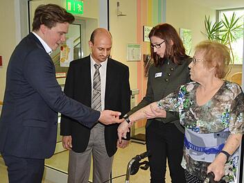 Die Patienten wie hier Helga Kirchner (rechts) werden mit speziellen Armbanduhren ausgestattet, die ein Signal absenden. David Martin (links) erklärt Abdulrahman Al-Hommadi aus Saudi-Arabien und Klinikchefin Sabine Hein, wie das funktioniert. Fotos: Kathrin Kupka-Hahn