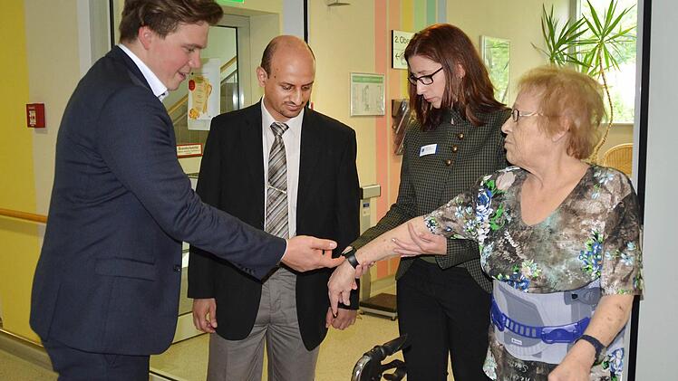 Die Patienten wie hier Helga Kirchner (rechts) werden mit speziellen Armbanduhren ausgestattet, die ein Signal absenden. David Martin (links) erklärt Abdulrahman Al-Hommadi aus Saudi-Arabien und Klinikchefin Sabine Hein, wie das funktioniert. Fotos: Kathrin Kupka-Hahn
