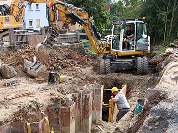 Die alte Brücke am Lanzenweg ist abgerissen. Jetzt werden mehrere große Stahlspund-Elemente eingebaut. Sie sollen ein Abrutschen des Hanges verhindern. Der Bach Aschach verläuft derzeit in einem Rohr. Foto: Kathrin Kupka-Hahn