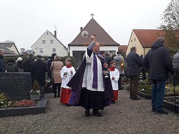 In Lettenreuth besprengte Pfarrer Rebhan die Gräber mit Weihwasser. Foto: Horst Habermann