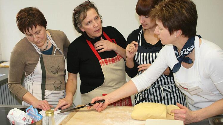 Kursleiterin Monika Hegwein erklärt Petra Hopfengart, Doris Seelkopf und Ramona Bayer, wie der Teig weiterverarbeitet werden muss. Foto: Daniela Röllinger