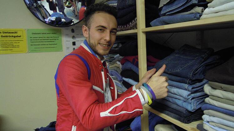 Helal Abdulghani beim Sortieren der Kleidungsstücke. Foto: Julia Raab