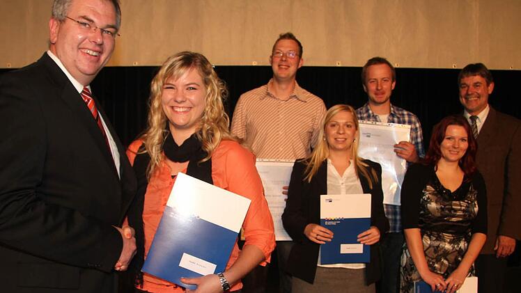 IHK-Vizepräsident Michael Möschel schüttelt Sandra Schedel die Hand. Auch Mathias Förtsch, Sandra Reuter, Stefan Schedel und Bianca Baumann haben die Prüfungen mit Erfolg abgelegt.