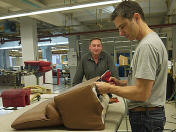 Als Leiter der Qualitätssicherung schaut Swen Hoese (links) auch immer wieder mal in der Polsterei vorbei - wie hier bei seinem Kollegen Thomas Schäfer, der auch schon über zwei Jahrzehnte Erfahrung als Polsterer hat. Foto: Berthold Köhler