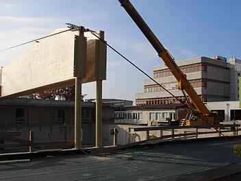 Während der Kollegstufenbau des Gymnasiums (im Hintergrund) auf eine Sanierung wartet, wird an der neuen Sporthalle (vorne) der Dachstuhl aufgerichtet. Foto: Andreas Dorsch