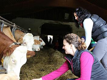 Katrin Ranninger zeigt Besucherin Tina Völkel, wie die Kühe gefüttert werden. Foto: Katharina Müller-Sanke