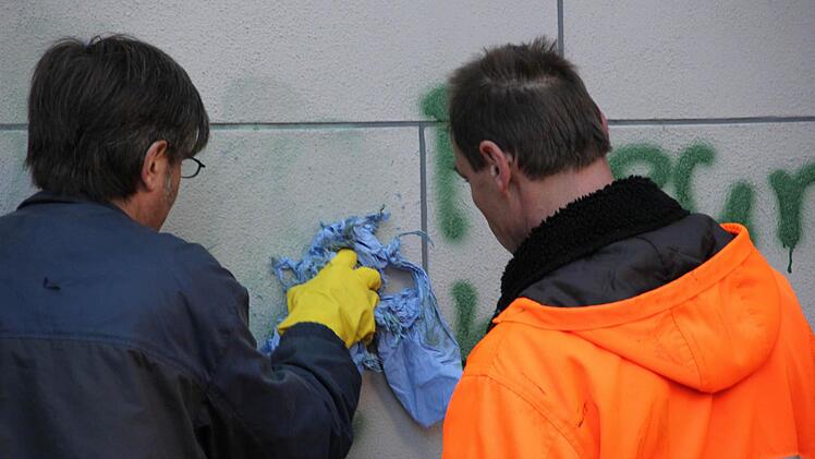 ...der Auftraggeber dieser beiden Bauhofmitarbeiter ist die Stadt Ha&szlig;furt: Dirk Laupenm&uuml;hler (links) und Peter Gr&auml;f waren am Mittwochnachmittag damit besch&auml;ftigt, die teils obsz&ouml;nen Schmierereien an der Ritterkapelle wieder zu entfernen.