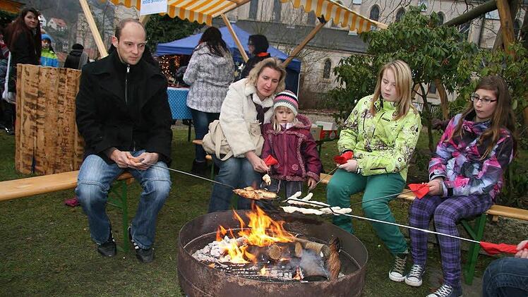 Perfektes Idyll: Am Feuerschein grillen die Kinder und Erwachsenen Stockbrot.